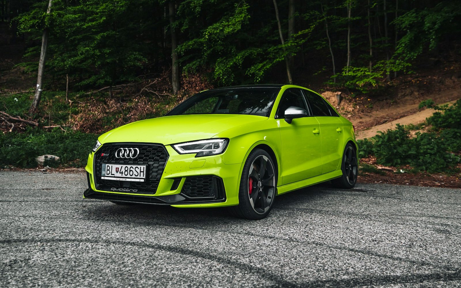 Lime green Audi RS3 8V saloon on a forest road