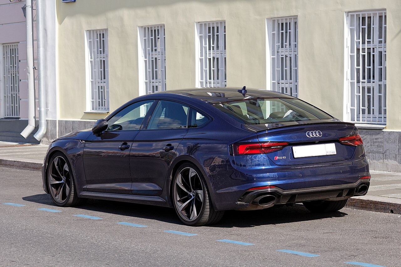Dark blue Audi RS5 Sportback B9 parked on a city street, seen from the rear