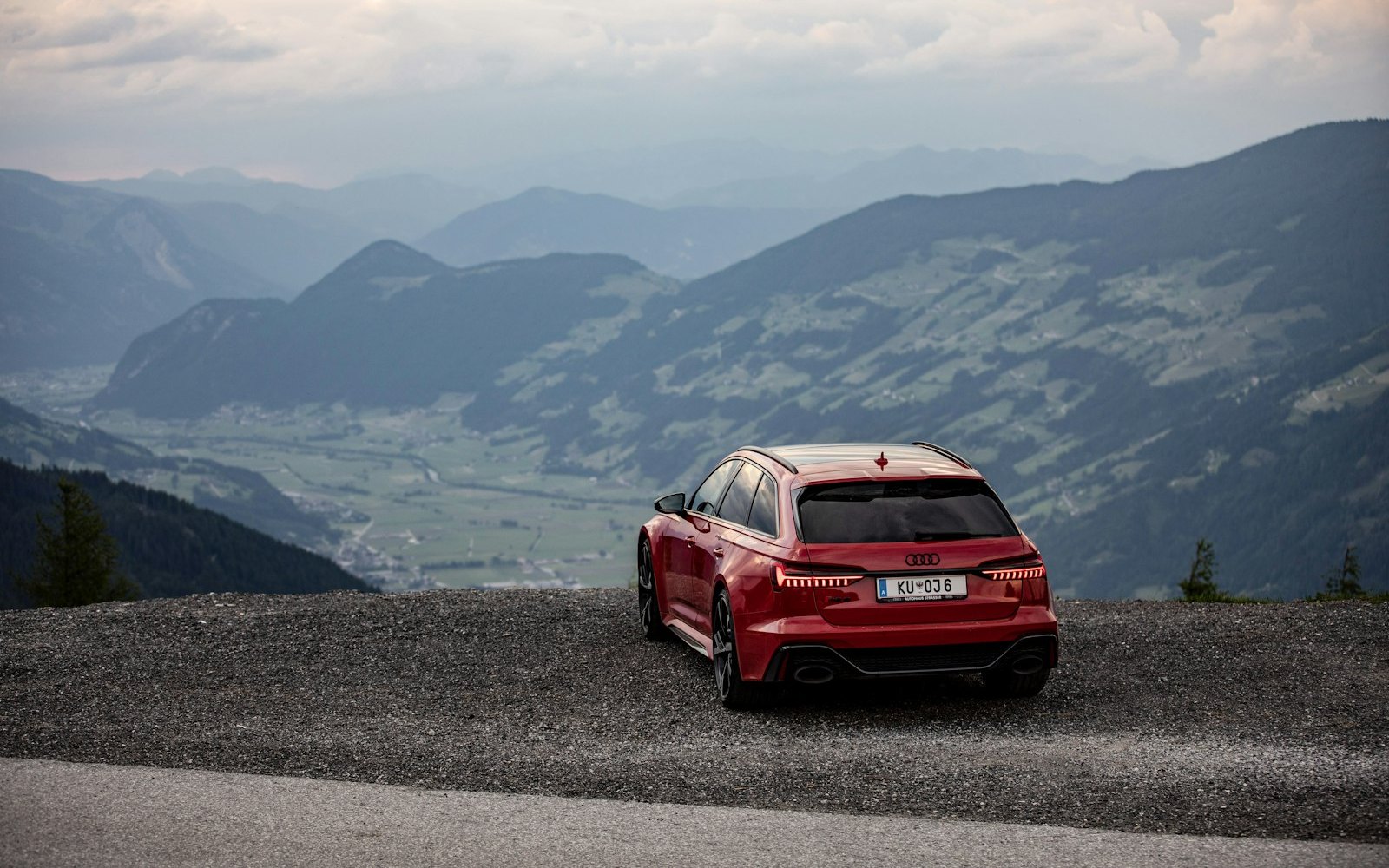 Red Audi RS6 Avant C8 parked at a mountain viewpoint