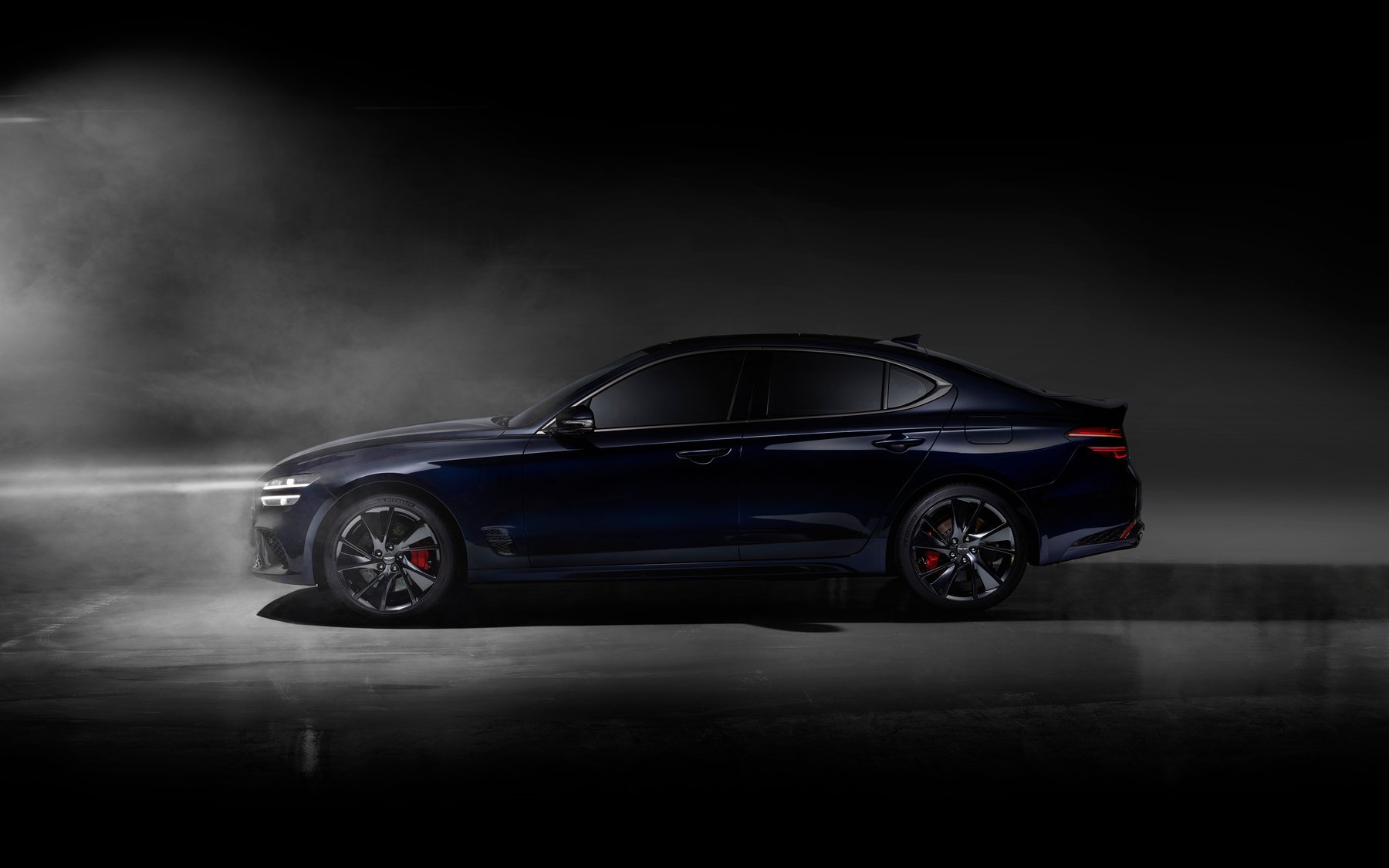 Dark blue Genesis G70 after its 2022 facelift, with red Brembo brakes, in a studio