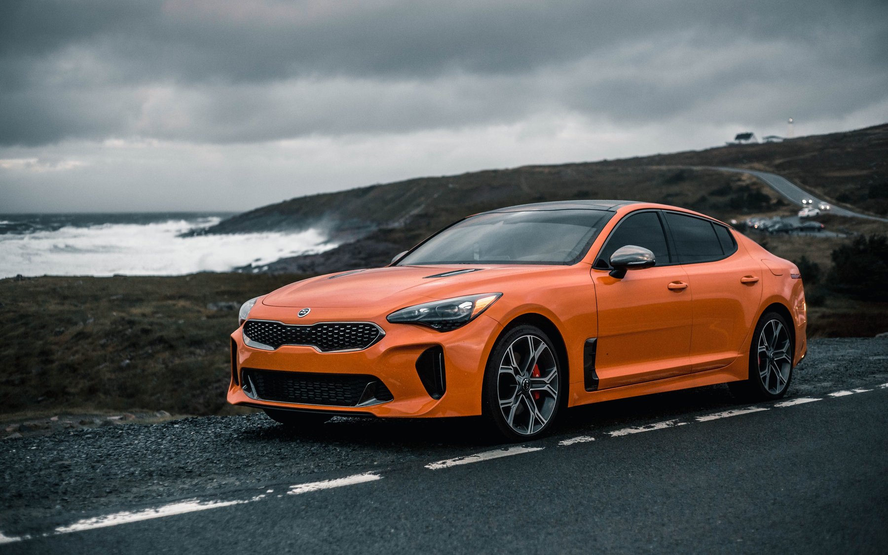 קיה סטינגר GTS בכתום Neon Orange, מהדורה מוגבלת שנבנתה על הסטינגר GT, חונה ליד הים