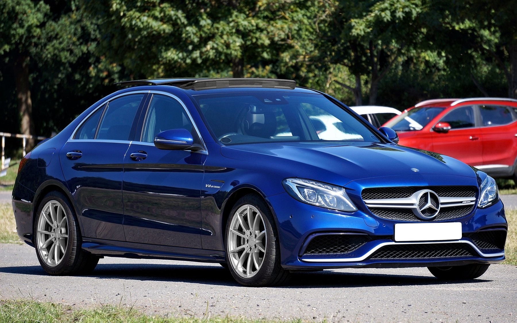 Blue Mercedes-AMG C63 W205 saloon with the V8 biturbo badge, parked on a sunny day