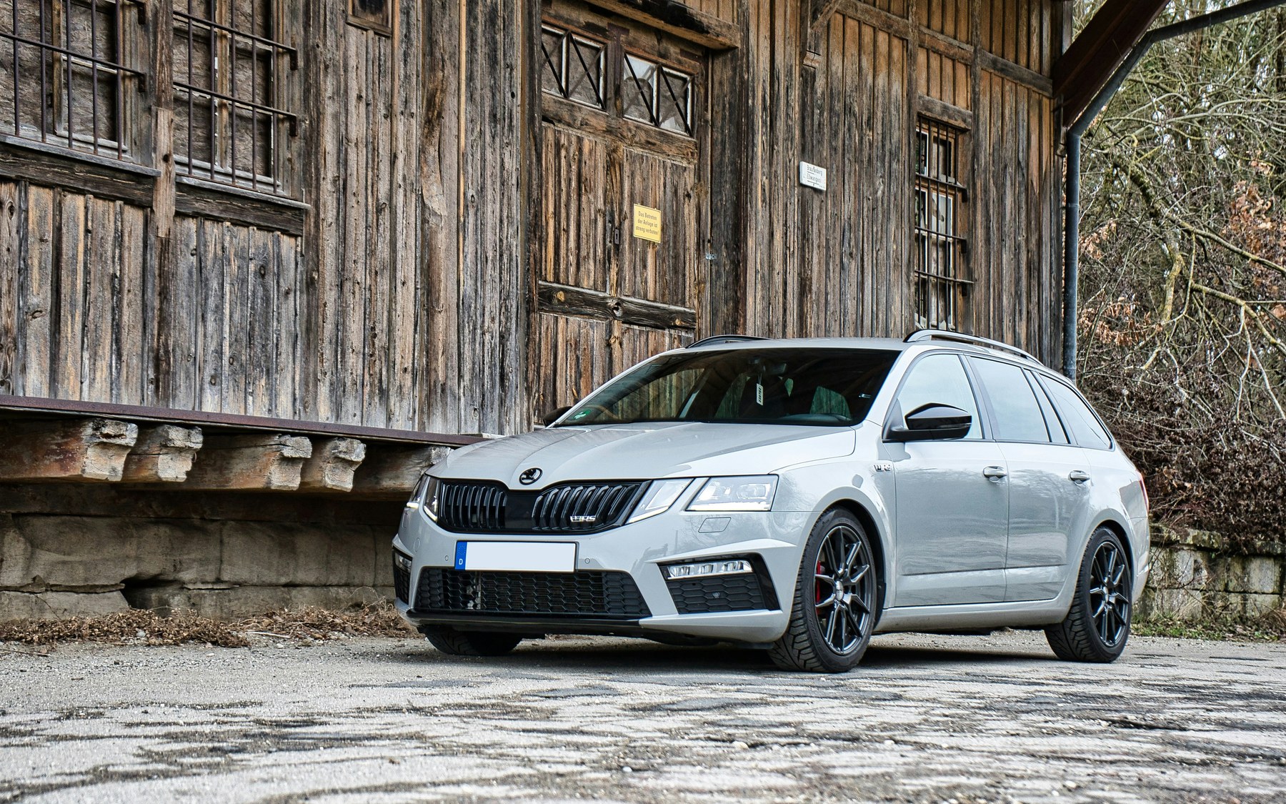 Grey Skoda Octavia vRS Mk3 estate, facelift, with the vRS grille badge and RS bumper, parked in front of an old wooden shed