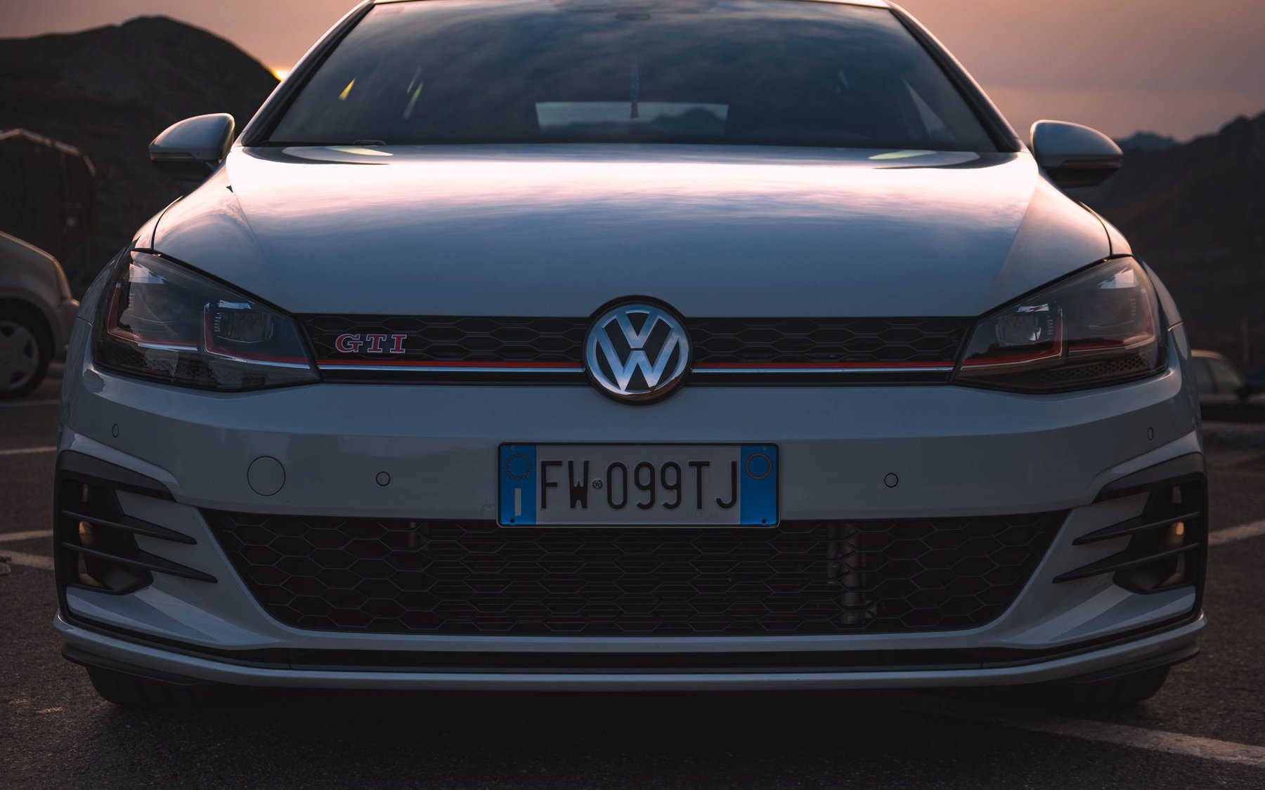 White Volkswagen Golf GTI Mk7.5 seen from the front at sunset